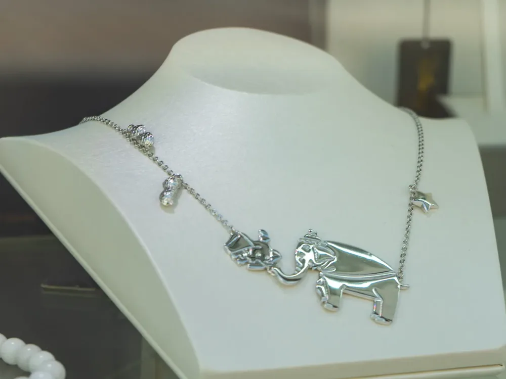 Couture Kingdom ezüst nyaklánc figurális medállal és apró függőkkel, kirakati nyakbábun